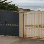 Portail alu ou acier : lequel résiste le mieux à la corrosion en zone côtière Portail noir et portail blanc rouillé face à l'océan